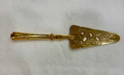 Pala antigua dorada para servir tartas con decoración floral